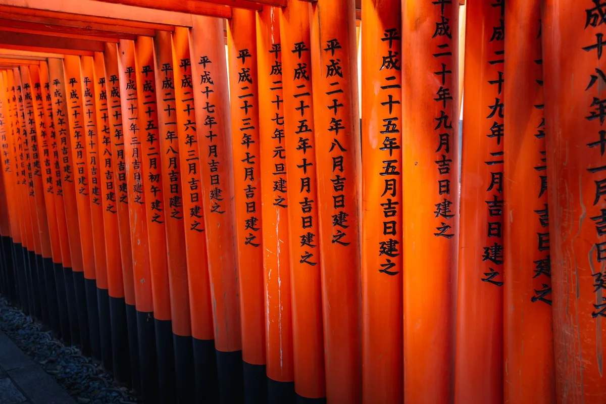 Rows of vermilion torii gates forming a tunnel at Fushimi Inari Taisha
