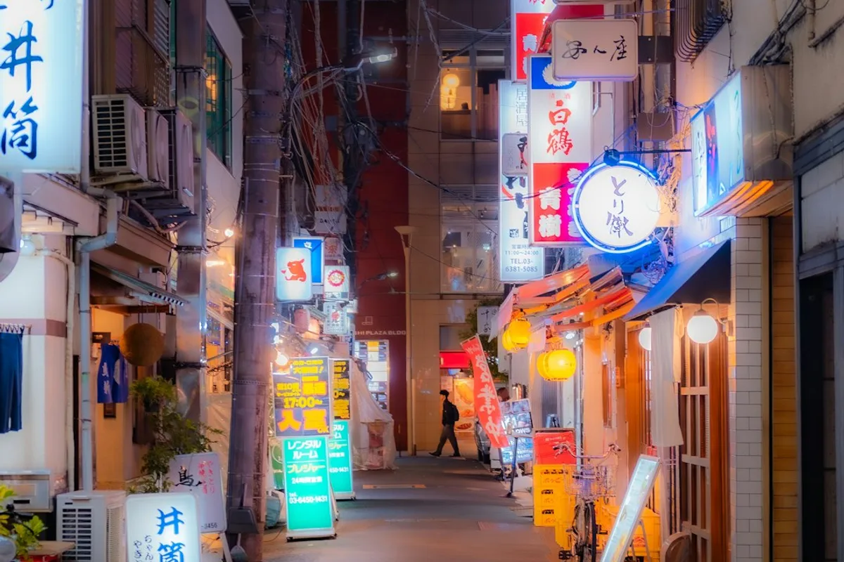 A narrow lantern-lit alley in a Japanese city at night