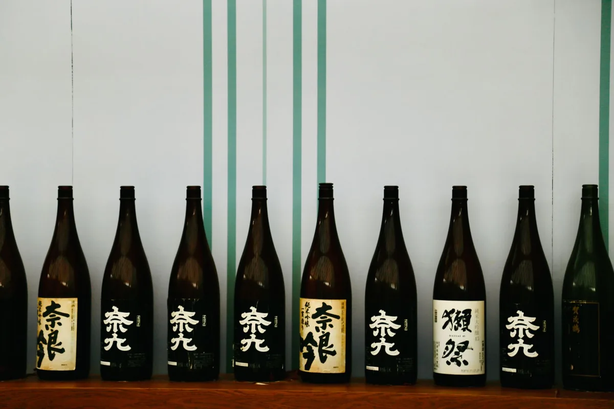Bottles of Japanese sake lined up at a small Gion bar